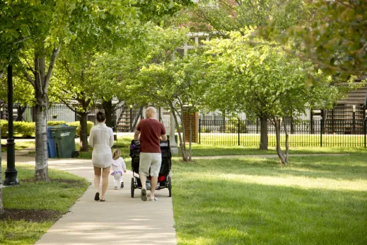 Parents and child pushing a stroller in a public park in the South Loop Chicago