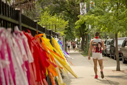 Pedestrian walking near decorated apartment fence in Lakeview Chicago