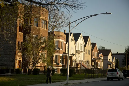 Pedestrian walking through neighborhood with apartments and houses in South Shore Chicago