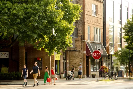 Pedestrians walking with apartments in the background in Roscoe Village