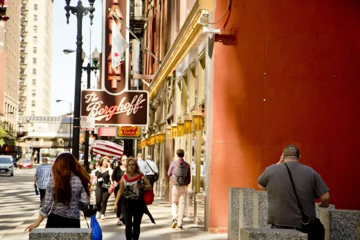 Pedestrians walking in front of Berghoff Restaurant sign in Chicago Loop