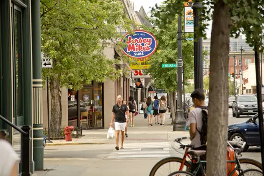 Pedestrians walking by local businesses on West Briar Place in Lakeview Chicago