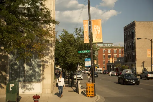 Pedestrians walking on sidewalk on N Racine Ave and W Chicago Ave intersection in River West Chicago