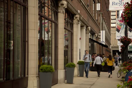 Pedestrians walking on sidewalk by office buildings in Fulton Market Chicago