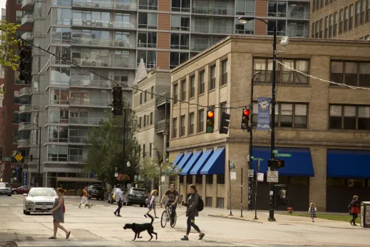 People crossing the street and traffic light at S Dearborn St with apartments in the background in Dearborn Park Chicago