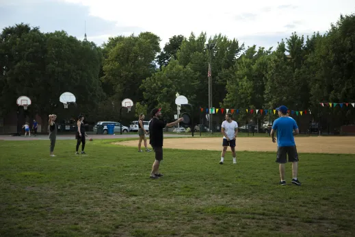 People playing frisbee near baseball diamond playing fields in Wicker Park Chicago
