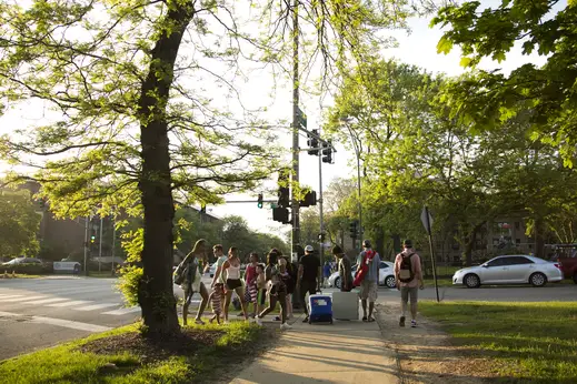 People walking across N Sheridan Rd from the beach in Rogers Park