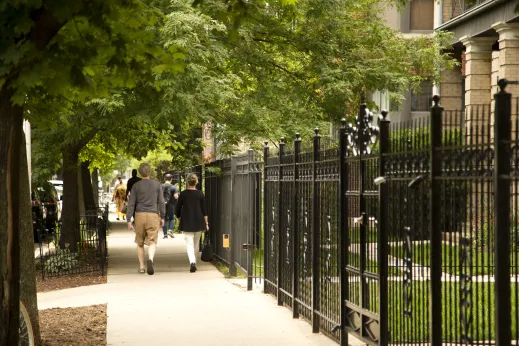 People walking by apartment building gates in Buena Park Chicago