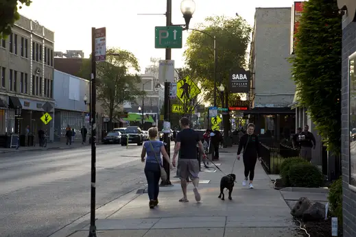 People walking their dog on street in Logan Square Chicago