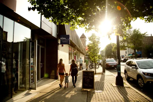 People walking on sidewalk on W Roscoe St passed shops in Roscoe Village