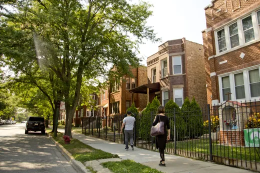 People walking on sidewalk by apartment buildings in Portage Park Chicago