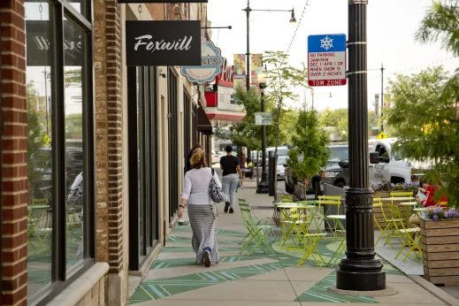 People walking on sidewalk by local businesses on North Milwaukee Avenue in Portage Park