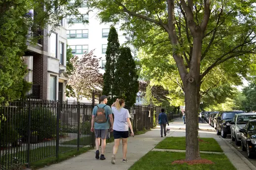 People walking on sidewalks in front of Uptown apartment buildings in Uptown Chicago Chicago