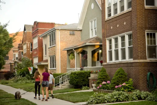 People walking with dog and front yards of apartment buildings in Lincoln Square Chicago