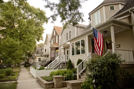 Single family homes and front yards with porches and the American Flag in Hamlin Park Chicago