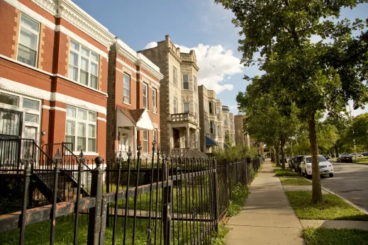 Vintage apartments and front lawns on neighborhood street in East Garfield Park Chicago