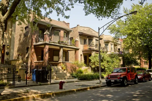 Vintage apartment balconies and red Jeep Wrangle parked in Margate Park Chicago