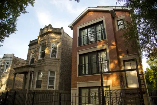 Vintage greystone apartment building beside modern three flat apartment building in North Lawndale Chicago