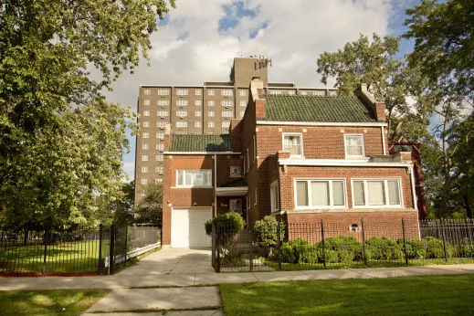 Vintage home with tile roof and apartments in background in East Garfield Park Chicago