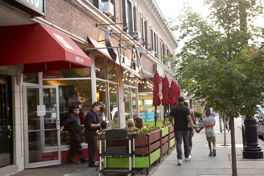 Waiter serving diners at outside patio seating at restaurant in Hyde Park
