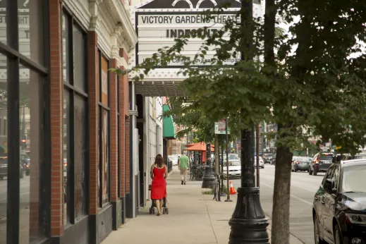 Woman walking in front of Victory Gardens Theater marquee in DePaul Chicago