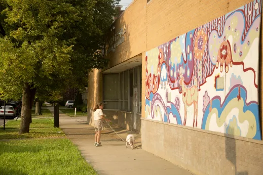 Woman walking dog by public art wall mural in Hollywood Park