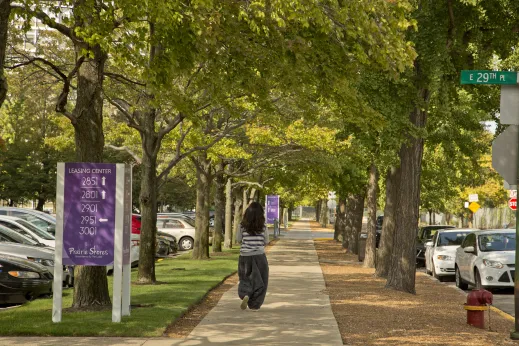 Woman walking on sidewalk by Prairie Shores Apartments in Douglas Chicago