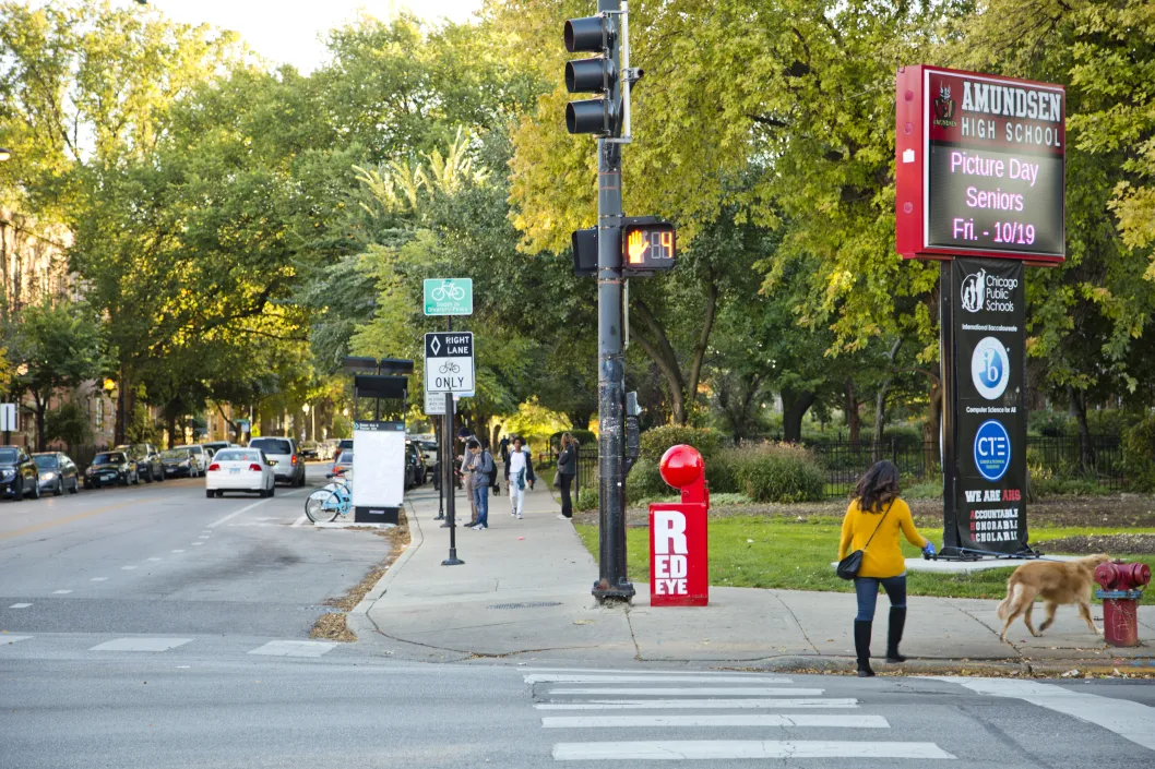 woman walking kids on busy street in Bowmanville Chicago