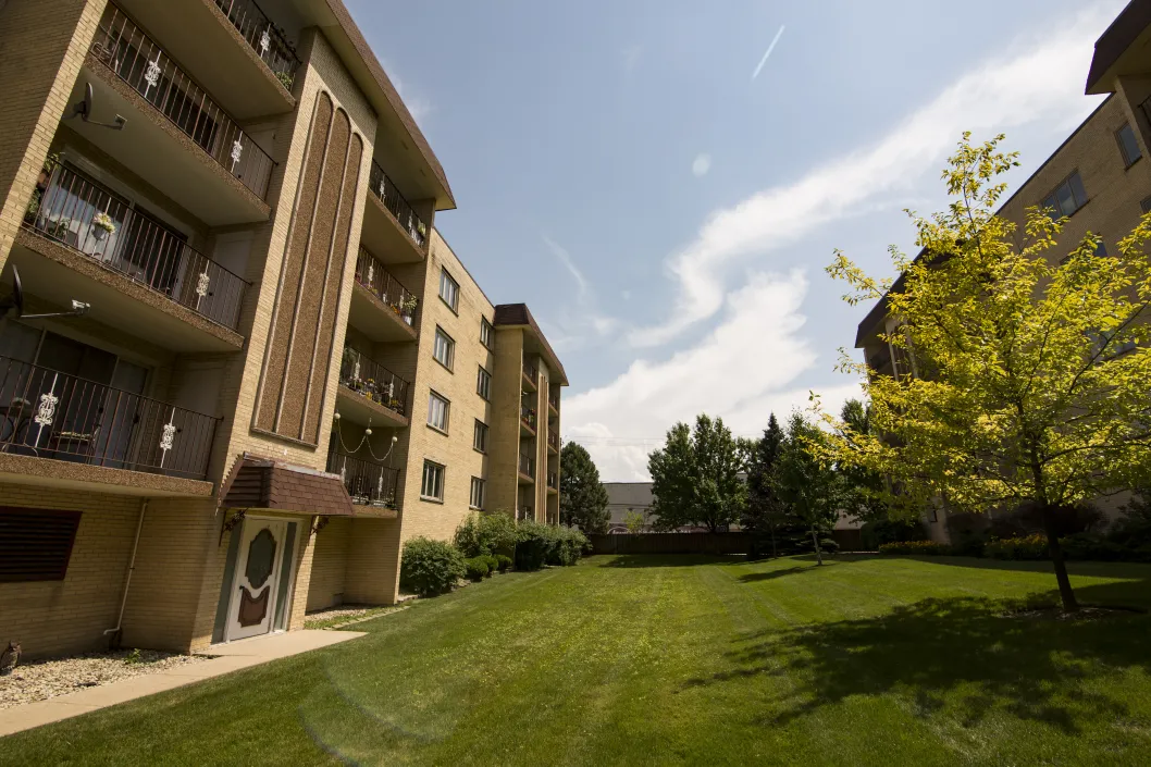 fresh mowed grass in front of brick apartment buildings with balconies in Dunning Chicago