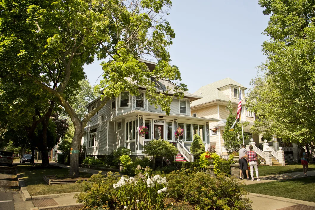 Family walking by houses and garden in Portage Park Chicago