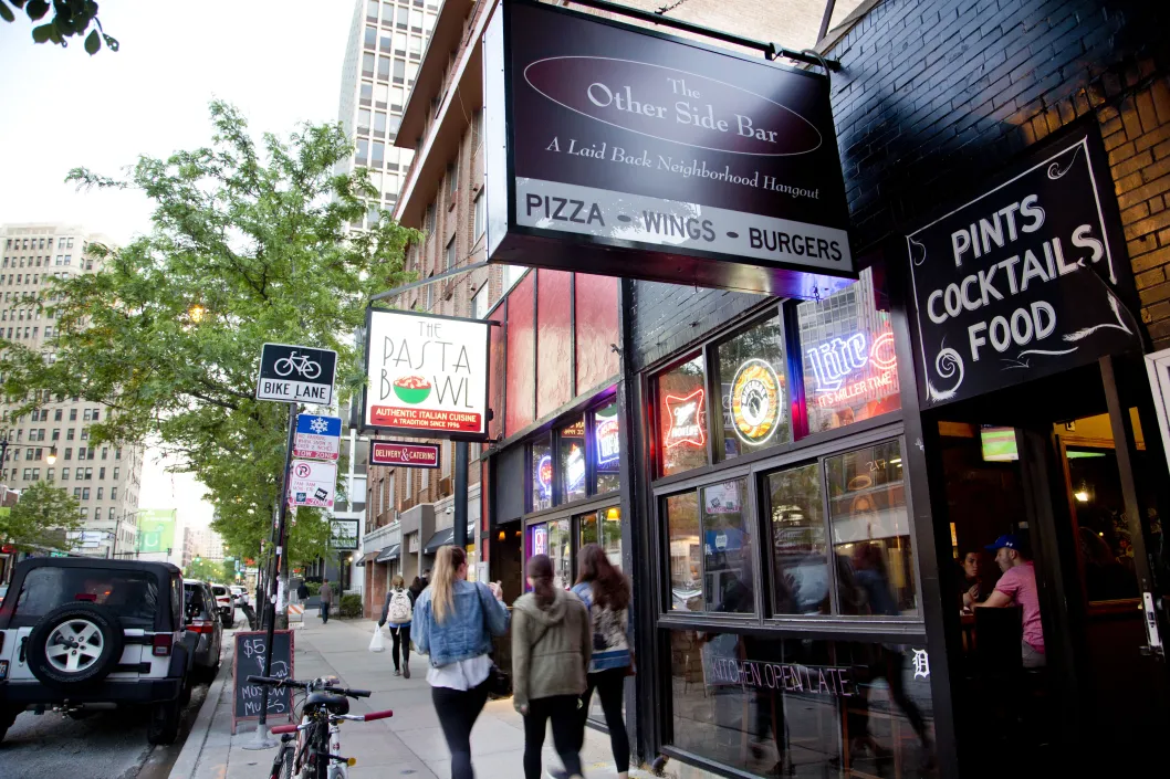 Pedestrians walking by The Other Side Bar entrance in Lincoln Park