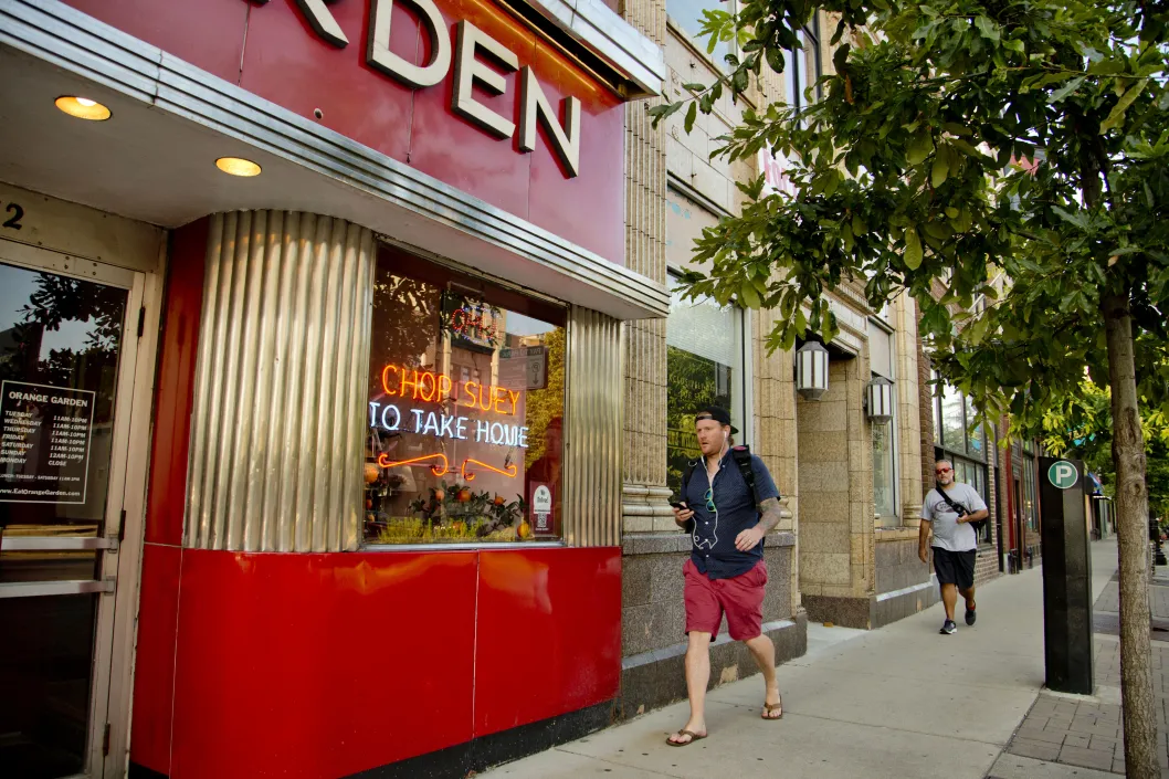 Pedestrians walking on West Lawrence Avenue Orange Garden restaurant entrance in North Center